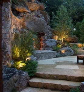primitive looking outdoor fireplace set into boulder walls