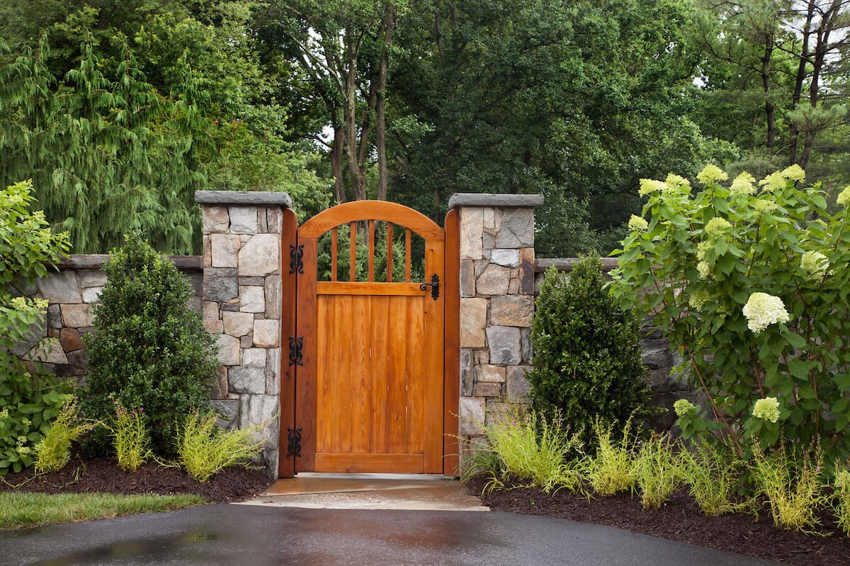 garden gate flanked by hydrangeas