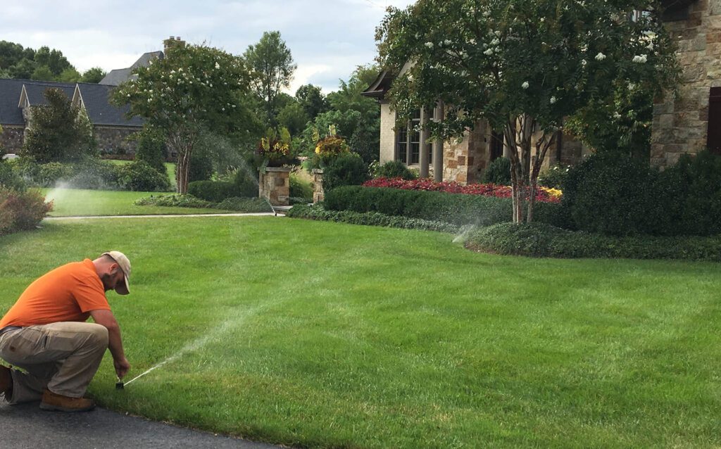 landscaper adjusting lawn and garden irrigation system
